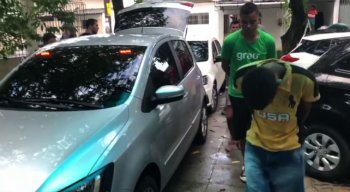 Suspeito chega escoltado por policiais à Delegacia do Ibura