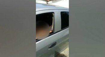 Ao perceber que estava sendo filmado, o homem fecha o vidro e foge com o veículo