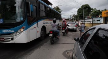 Por falta de calçadas em vias do bairro, pedestres dividem espaço com carros, motos e ônibus