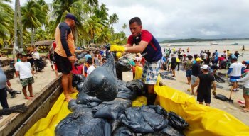 Voluntários retiram manchas de óleo do litoral pernambucano