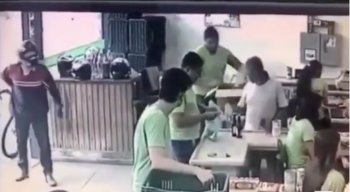 O homem coloca a mão por dentro da camisa para simular uma arma