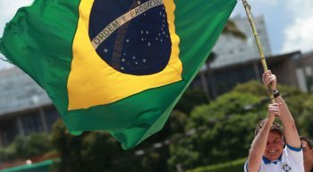 Presidente Jair Bolsonaro balança bandeira do Brasil