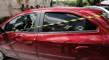 O homem estava dentro do carro vinho e foi morto com pelo menos 12 tiros