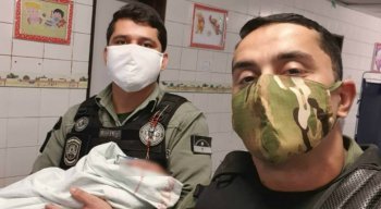 Os policiais militares, sargento De Lima e soldado Ellyson, com o bebê que foi salvo