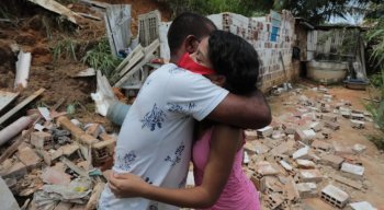 Vitória abraça pai em meio aos escombros da casa da família