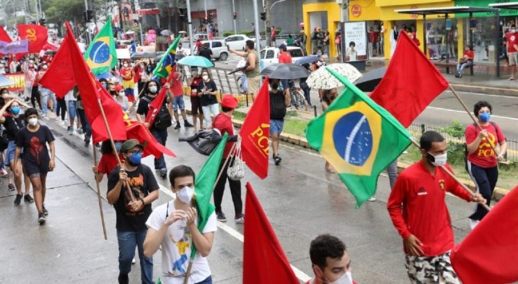 Manifestantes contra Bolsonaro usam bandeira do Brasil.