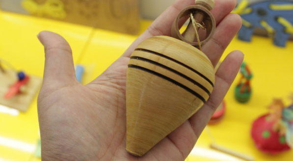 Pe&atilde;o em uma m&atilde;o com mesa amarela de fundo.