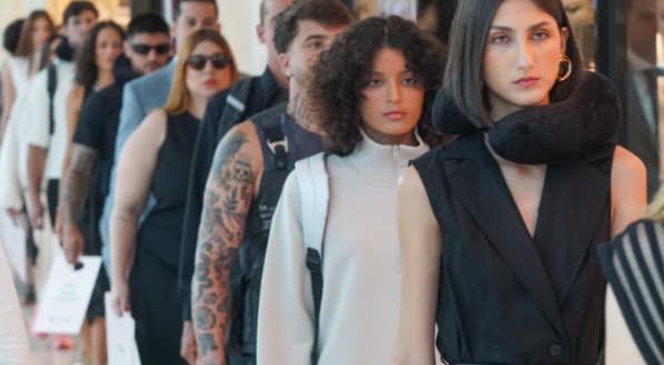 V&aacute;rios modelos est&atilde;o em uma fila. As primeiras usam roupas em preto e cinza.