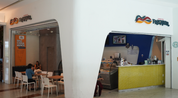 A imagem mostra a fachada da FriSabor, com uma entrada em formato de "L" e um balcão de atendimento amarelo.