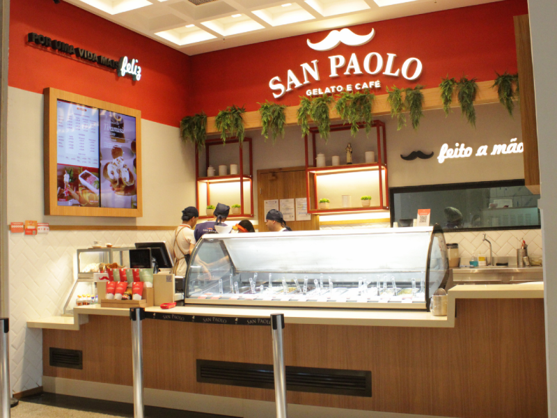 A imagem mostra a fachada da San Paolo, com paredes vermelhas e um logo de bigode. 
