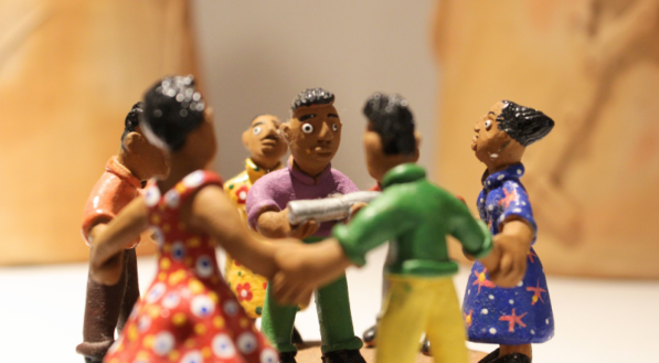 A imagem mostra uma escultura de barro representando uma ciranda