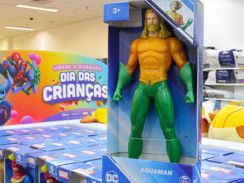 A imagem mostra um boneco do Aquaman na caixa.