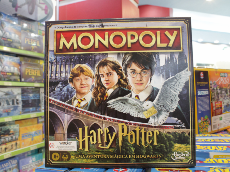 A imagem mostra a caixa do jogo de tabuleiro Monopoly com o tema "Harry Potter", apresentando os personagens principais.