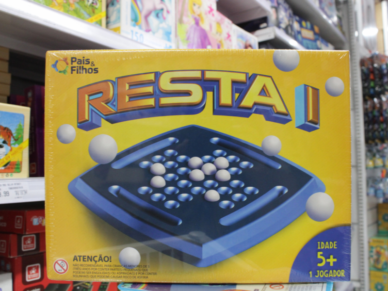 A imagem mostra a caixa do jogo "Resta 1" da Pais ENTITY_amp_ENTITYFilhos, em um fundo amarelo.