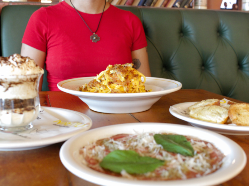 A imagem mostra uma mesa posta com o Carpaccio, o Spaghetti à Carbonara e o Tiramisù.