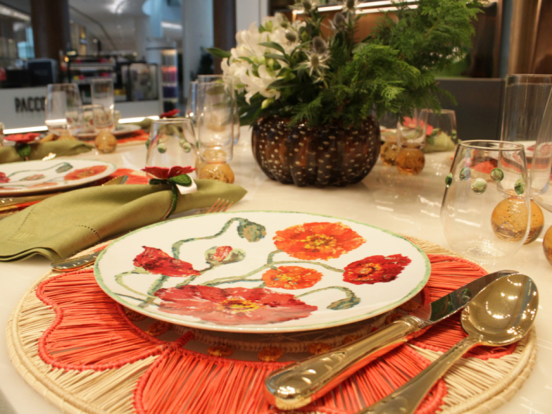 A imagem mostra um close-up em um prato raso da Coleção Papoula, posicionado sobre um sousplat de palha em tom laranja/coral. A imagem mostra um close-up em um prato raso da Coleção Papoula, posicionado sobre um sousplat de palha em tom laranja/coral.