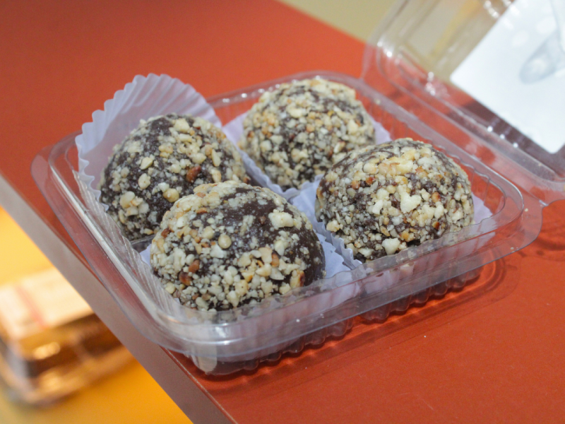 A imagem mostra uma caixa com quatro brigadeiros saudáveis sabor cacau e amendoim A imagem mostra uma caixa com quatro brigadeiros saudáveis sabor cacau e amendoim