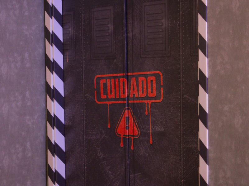 Uma porta escura com um design industrial exibe um aviso central em vermelho escorrendo: a palavra 