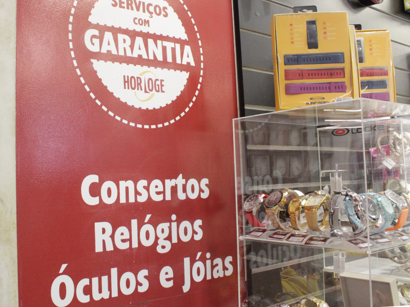 A imagem mostra uma placa na cor vermelha com informações sobre serviços e garantia.