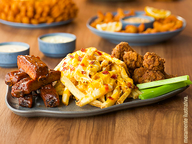 Uma travessa retangular com uma combinação de aperitivos: costelinhas de porco (ribs) cobertas com molho barbecue, batatas fritas com queijo e bacon, e pedaços de frango frito. Há talos de aipo (salsão) para acompanhar.