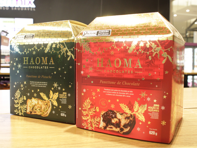 Duas caixas de Panetones da marca HAOMA Chocolates, nas cores verde e vermelho, com foco no selo 