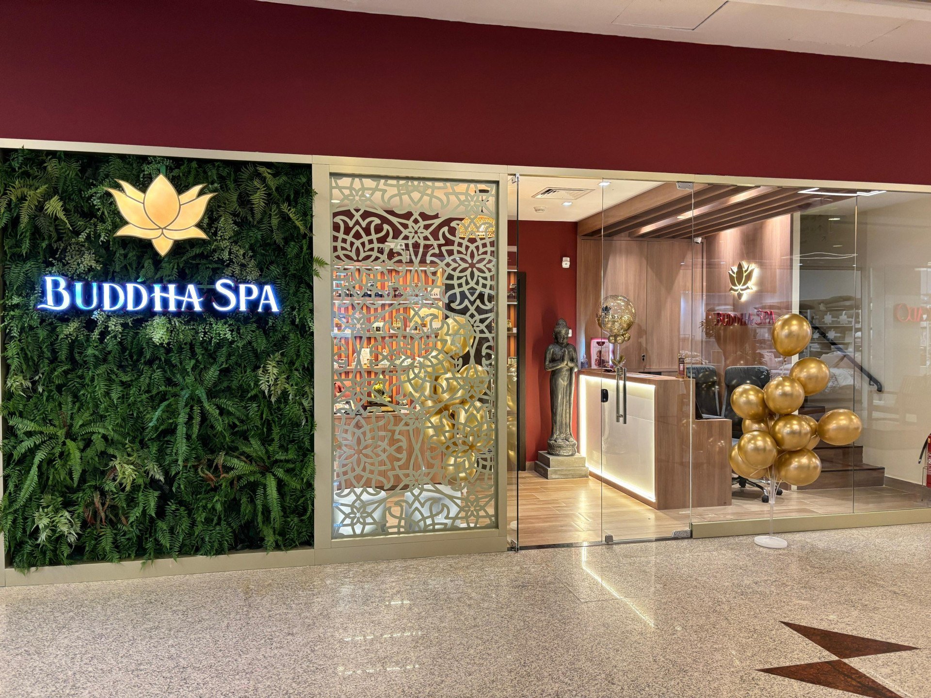 imagem da fachada da loja com parede preenchida com plantas ao lado de uma vitrine de vidro