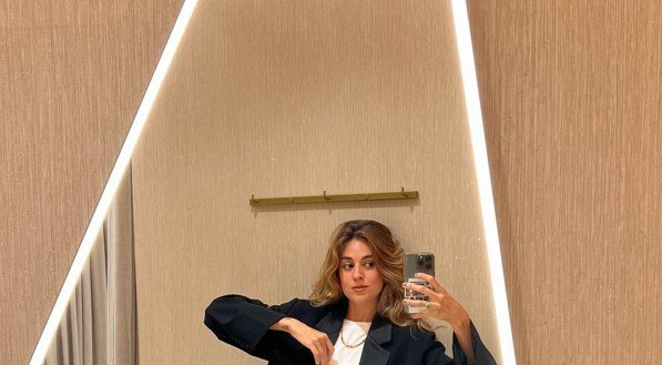 O destaque é o blazer cropped com ombreiras marcadas — uma peça que flerta com os anos 80 