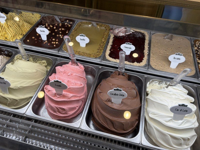 Vitrine com opções de Geltato, entre eles: Fior di Latte; Cincollato Belga; Fragola; Pistachio; Gianduia; Borellito; Cheescake e Mocciolito.