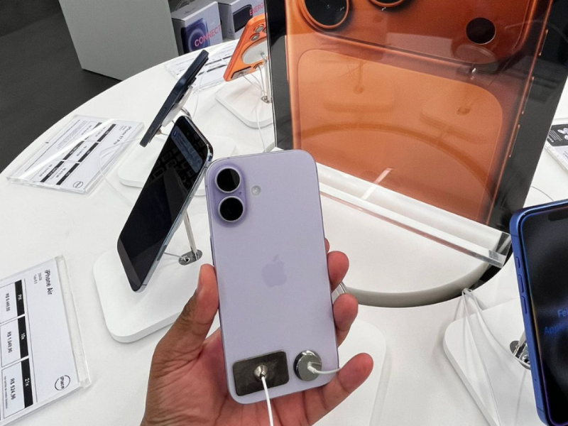 Mão masculina segurando o novo iPhone 17 mostrando a parte traseira.