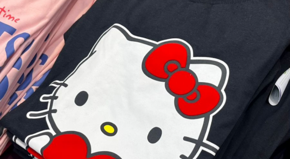 camisa dobrada, de cor preta e estampa da hello kit centralizada em tamanho grande.