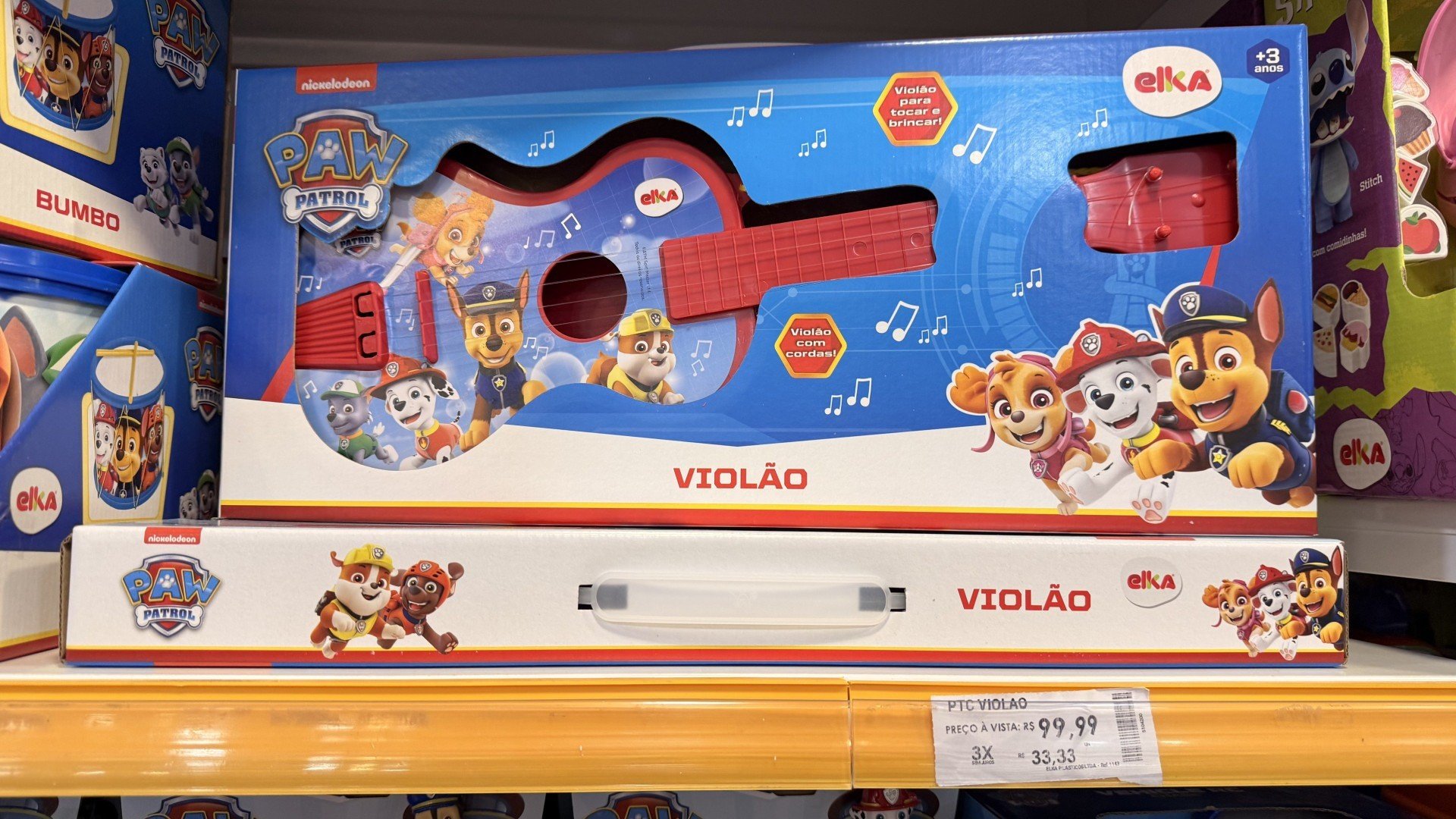 Violão com tema de Patrulha Canina na cor vermelha e imagem dos filhos impressa na parte das cordas. Valor de 99,99 reais. 
