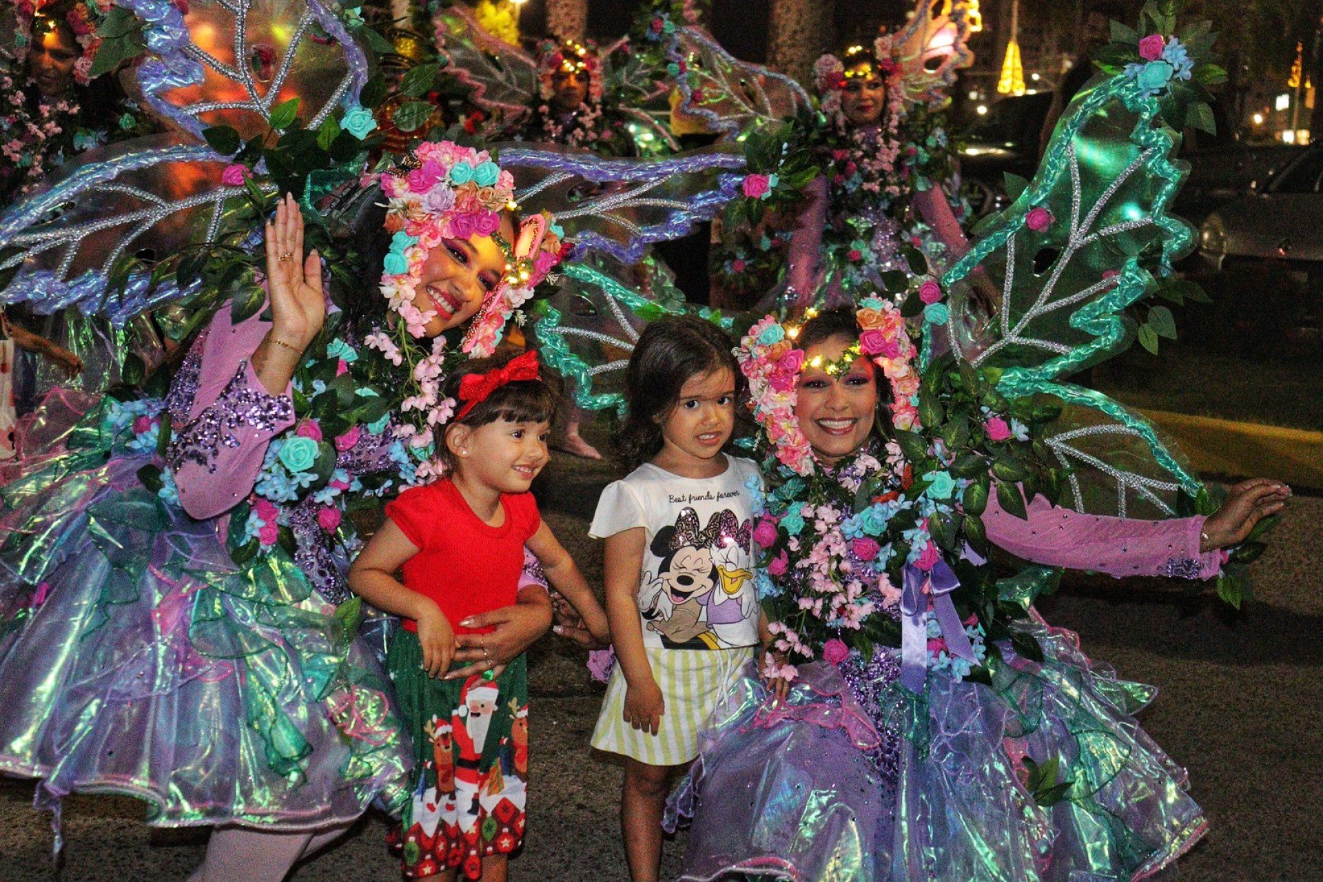 Crianças posam com artistas vestidas de Borboletas. Elas sorriem felizes.  Crianças posam com artistas vestidas de Borboletas. Elas sorriem felizes.