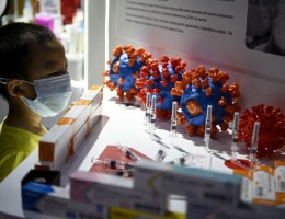 Menino observa vacina candidata da Sinovac Biotech contra o novo coronavírus em exibição na Feira Internacional de Comércio de Serviços da China em Pequim
