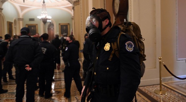 A US Capitol police officer wears agas mask as supporters of US President Donald Trump enter the Capitol on January 6, 2021, in Washington, DC. Demonstrators breeched security and entered the Capitol as Congress debated the a 2020 presidential election El