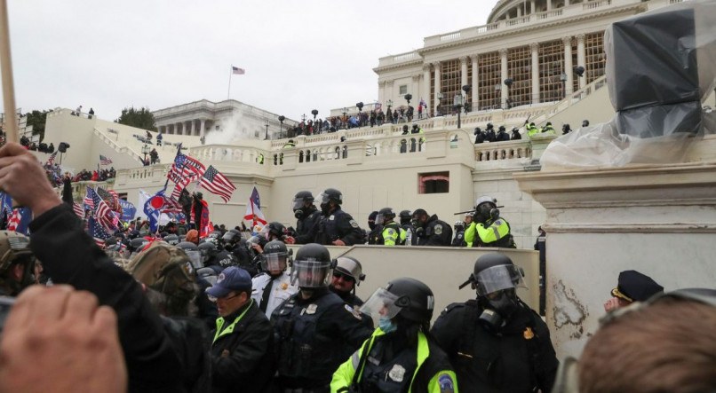 Policiais americanos montam guarda enquanto apoiadores do presidente norte-americano Donald Trumb protestam em frente ao Capitólio em Washington.