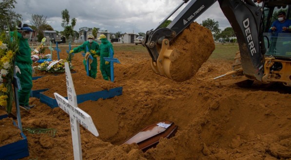 Coveiros enterram uma v&iacute;tima da covid-19 cercados por parentes no cemit&eacute;rio Nossa Senhora Aparecida em Manaus