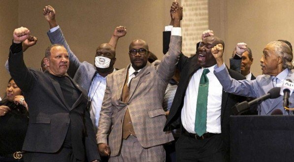 O irm&atilde;o de George Floyd, Philonise Floyd (C), flanqueado pelo reverendo Al Sharpton (2&ordm; L) e o advogado Ben Crump (R), ergueu os bra&ccedil;os durante uma entrevista coletiva ap&oacute;s o veredicto no julgamento do ex-policial Derek Chauvin em Minneapolis, Minnesota