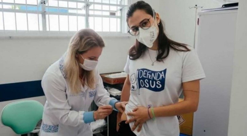 Laura Braz publicou foto no Twitter depois de receber a vacina contra a covid-19 no ventrogl&uacute;teo.