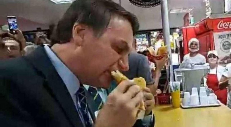 O presidente Jair Bolsonaro comendo pastel no Distrito Federal, em 2019