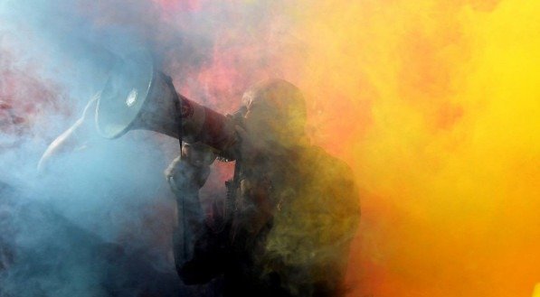 Um homem grita slogans com um megafone durante um protesto contra o G20 da C&uacute;pula de L&iacute;deres Mundiais em 30 de outubro de 2021 no distrito da Pir&acirc;mide de C&eacute;stio, em Roma.