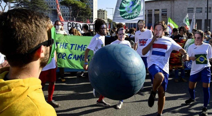 Ativistas do clima de 'Fridays for Future' usando m&aacute;scaras de l&iacute;deres mundiais participam de um protesto contra o G20 da C&uacute;pula de L&iacute;deres Mundiais em 30 de outubro de 2021 no distrito da Pir&acirc;mide de C&eacute;stio, em Roma.