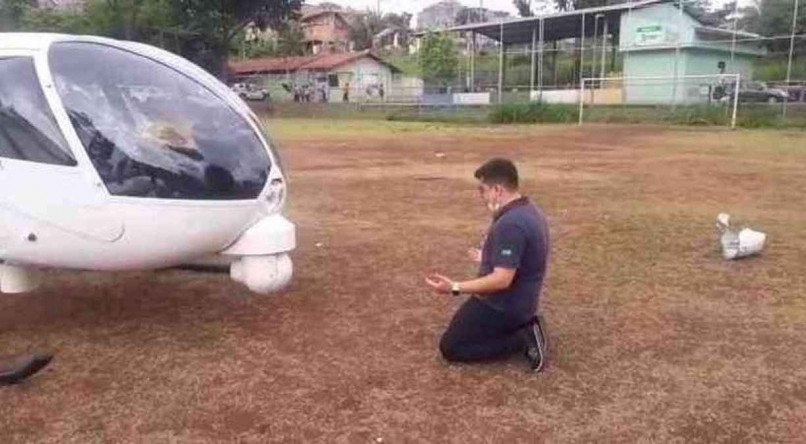 Dudu Barbatti, piloto do helic&oacute;ptero da Globo, se ajoelha e reza em frente a aeronave ap&oacute;s acidente