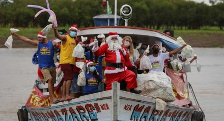 Integrante do grupo "Amigos do Papai Noel", fantasiado de Papai Noel, chega a Careiro da Várzea, cidade às margens do rio Amazonas, para dar presentes às crianças