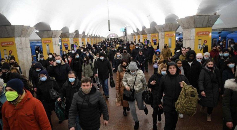 Pessoas, algumas carregando sacolas e malas, caminham em uma esta&ccedil;&atilde;o de metr&ocirc; na capital, Kiev