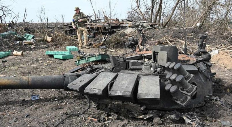 Soldado ucraniano observa tanque russo destruído