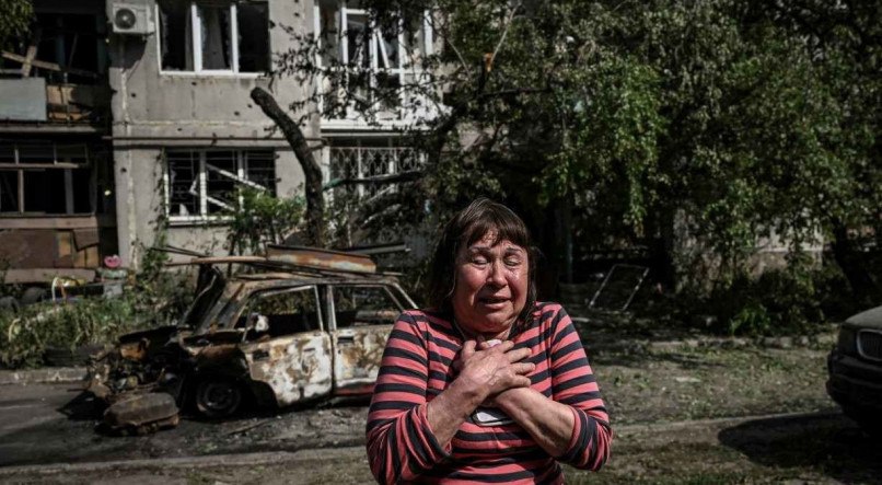 Uma mulher chora em frente a um prédio danificado após um ataque na cidade de Sloviansk