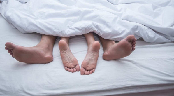 Casal com os pés para fora na cama (imagem ilustrativa de relação sexual, sexo)