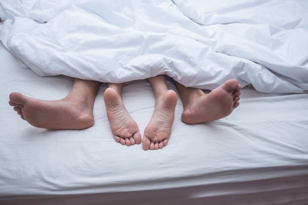 Casal com os pés para fora na cama (imagem ilustrativa de relação sexual, sexo)