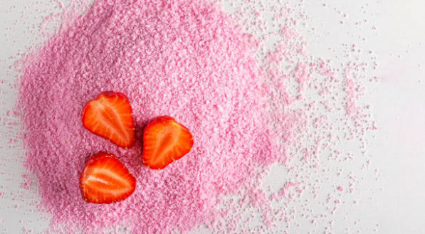 Pink dried strawberries powder with fresh raw berries on white background. Textured fruit starch,  jelly, gelatin for cooking ingredients