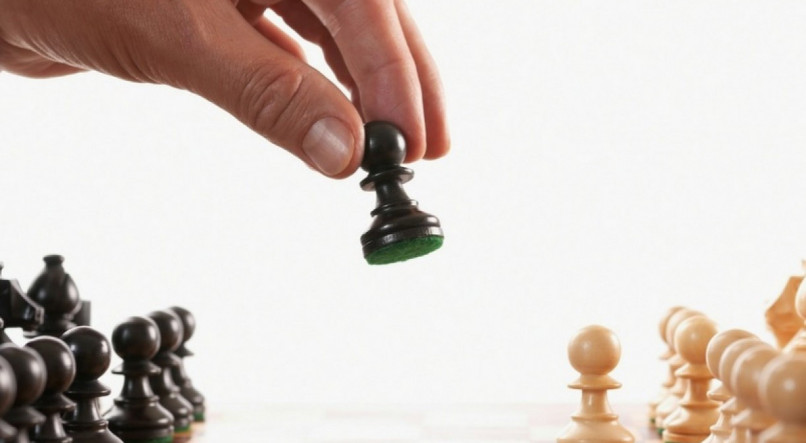 Homem movendo pe&ccedil;as de xadrez; manipulador